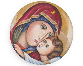 Könnte beinhalten: Rundes religiöses Symbol mit einer Darstellung der Jungfrau Maria und des Jesuskindes. Das Symbol hat einen goldenen Hintergrund mit Figuren in Rot, Blau und Weiß. Die Jungfrau Maria trägt eine rote Kopfbedeckung.