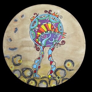 May include: A colorful, abstract painting on a round, tan background. The central figure is a sphere with intricate patterns in blue, red, yellow, and purple, supported by two patterned legs. The artwork is surrounded by dark circles and abstract shapes.