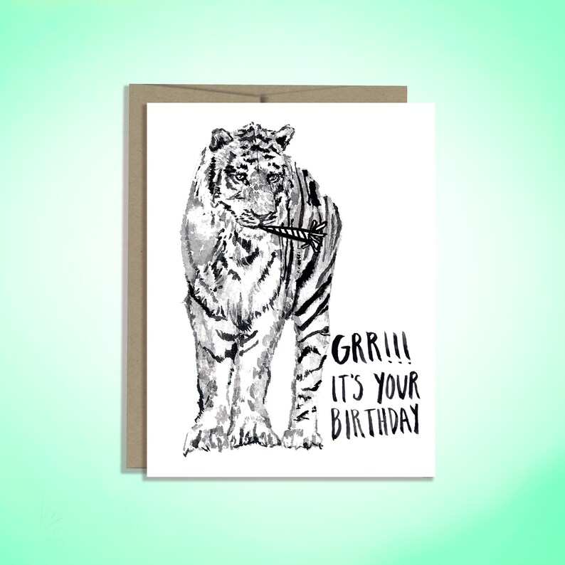 May include: A black and white illustration of a tiger holding a birthday candle in its mouth. The text "GRR!!! It's your birthday" is below the tiger.