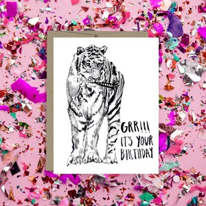May include: A black and white illustration of a tiger holding a party popper in its mouth. The text "GRR!!! It's your birthday" is written below the tiger.
