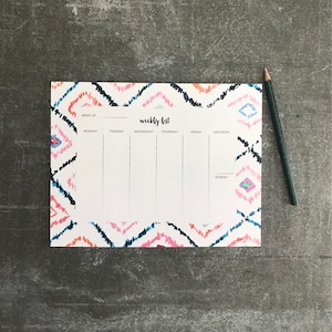 May include: A weekly list planner with a colorful geometric pattern. The planner has spaces for each day of the week, Monday through Sunday. The words "weekly list" are printed at the top of the planner.
