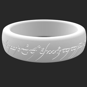 Puede incluir: Un anillo blanco con escritura grabada alrededor de la banda. El anillo tiene un diseño suave y redondeado y está sobre un fondo oscuro. El texto grabado está en una fuente estilizada.
