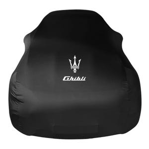 Pode incluir: Capa de carro preta com o logotipo do tridente Maserati e a palavra "Ghibli" em branco. A capa é projetada para caber em um carro, com uma aparência suave e ajustada.