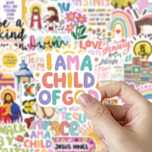 May include: A colorful sticker with the text "I AM A CHILD OF GOD" held by a hand. The sticker has a white border and is surrounded by other stickers with religious and inspirational themes, including rainbows, flowers, and script lettering.