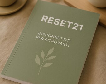 May include: A sage green book titled "RESET21" with the text "DISCONNETTITI PER RITROVARTI" and a leaf illustration. A cup of coffee and a small potted plant are in the background.