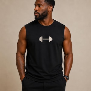 Könnte beinhalten: Ein schwarzes ärmelloses Tanktop mit einer mittig platzierten, hellen Grafik einer Hantel. Das Kleidungsstück verfügt über einen Rundhalsausschnitt und weite Armausschnitte und ist aus einem einfarbigen Stoff mit schlichter Optik gefertigt.
