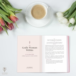 Puede incluir: Un diario guiado de 21 días abierto titulado The Godly Woman Within de Lexi Anderson, que presenta una página rosa claro con un icono de cruz y una página blanca con texto sobre God's Design for Femininity, junto a una taza de café y tulipanes.