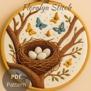 May include: Embroidered hoop art featuring a bird's nest with four eggs, surrounded by brown tree branches and colorful butterflies. The text "Floralya Stitch" and "PDF Pattern" are visible. The design is set against a cream-colored background.