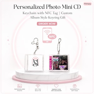 Może przedstawiać: Dwa przezroczyste mini breloki do płyt CD z akrylu ze srebrnymi łańcuszkami. Jeden ma logo, drugi różową okładkę albumu. Widoczny jest tekst "Personalized Photo Mini CD" i "Keychain with NFC Tag".