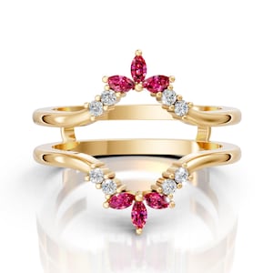 May include: A gold-colored ring guard with a floral design. The ring guard features marquise-cut pink gemstones and small white gemstones. The ring guard is designed to be worn with a ring.