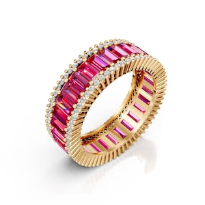 May include: A gold ring featuring a continuous band of vibrant pink rectangular gemstones. The ring is accented with small, round, clear gemstones and has a textured gold band. The gemstones are set closely together, creating a continuous, eye-catching design.