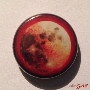 May include: A red and orange button with a close-up image of a full moon.