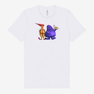 May include: White t-shirt featuring a cartoon illustration of two characters. One character is yellow and red, the other is purple and holding a tray with a burger and drink. The shirt is made of a soft material.