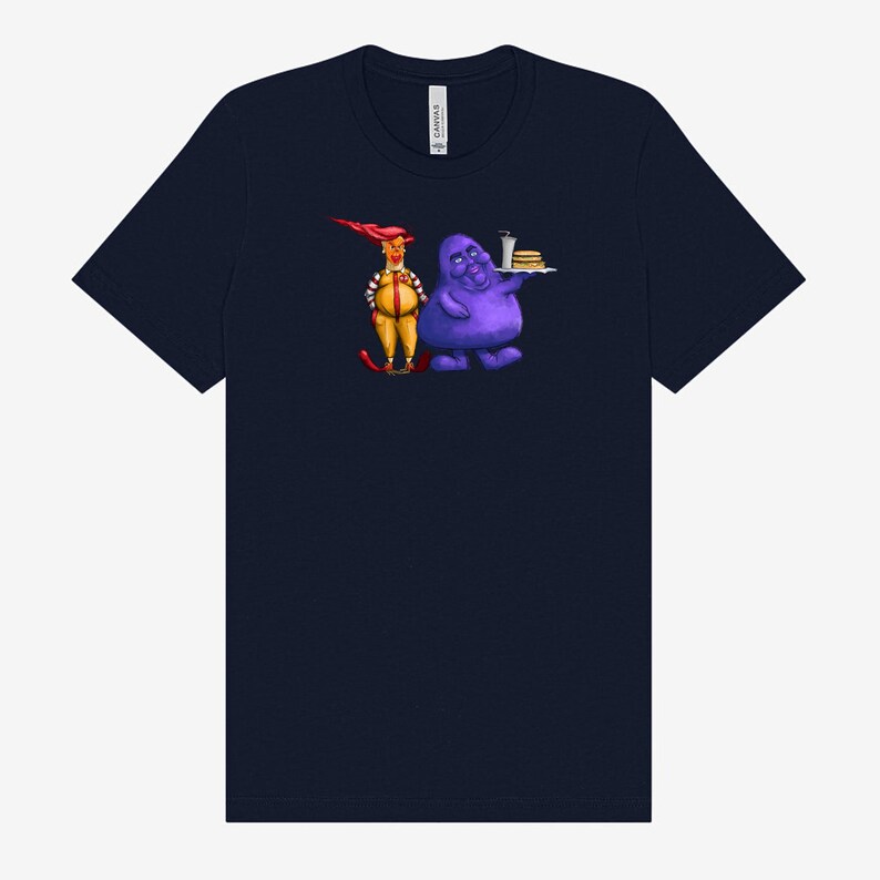 May include: Navy blue t-shirt featuring a cartoon illustration of two characters. One character is dressed in a yellow and red outfit, and the other is a purple blob holding a tray with a burger and drink.