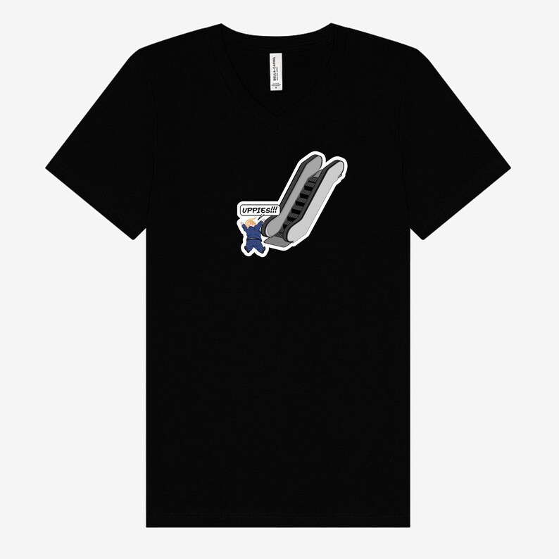 May include: Black V-neck t-shirt featuring a cartoon graphic of an escalator with a person in a suit and the text "UPPIES!!!" in a speech bubble. The graphic is in shades of gray, white, and blue.