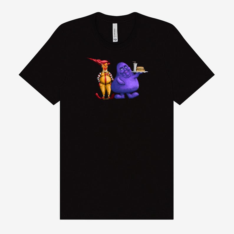 May include: Black t-shirt featuring a cartoon illustration of two characters. One character is dressed in a yellow and red uniform, and the other is a purple blob holding a tray with a burger and drink.