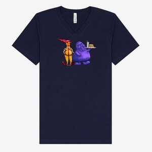 May include: Navy blue V-neck t-shirt featuring a cartoon illustration of two characters. One character is yellow with red hair and the other is purple and holding a tray of food. The t-shirt is made of a soft material.