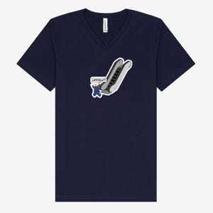 May include: Navy blue V-neck t-shirt featuring a cartoon graphic of an escalator with a person waving and the text "UPPIES!!!" in a speech bubble. The graphic is in shades of gray, white, and blue.