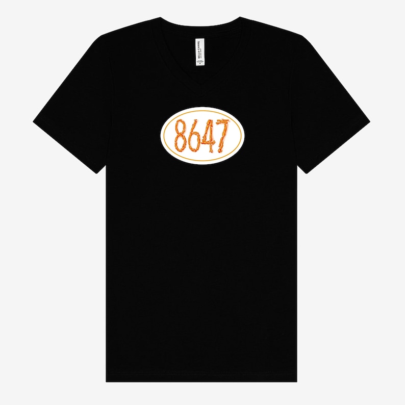 Black unisex T-shirt with white oval emblem, 8647 centered inside white emblem written out in Cheetos.  T-shirt is Bella & Canvas brand.