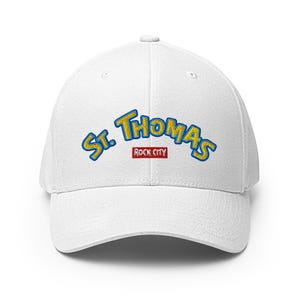 May include: A white baseball cap with the embroidered text "St. Thomas" in blue and yellow, with "Rock City" in a red rectangle. The cap has a curved brim and a structured fit.