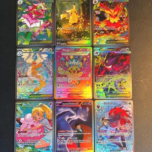May include: Nine colorful Pokémon trading cards featuring various characters like Pikachu, Mega Meganium, and Mega Emboar. Each card has unique artwork, character names, and numerical values.