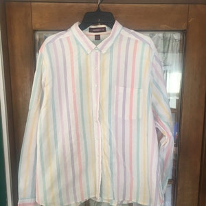 May include: A long-sleeved button-down shirt with a white background and colorful vertical stripes. The stripes are in shades of pink, yellow, green, and purple.