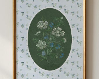Puede incluir: Una impresión botánica enmarcada con un ramo de flores blancas y azules dentro de un óvalo verde. El fondo es azul claro con un delicado estampado floral. El marco es dorado.