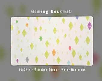May include: Gaming deskmat with a white background and a pattern of colorful diamond shapes. The desk mat is 35.5x61cm with stitched edges and is water resistant. The text "Gaming Deskmat" is at the top.