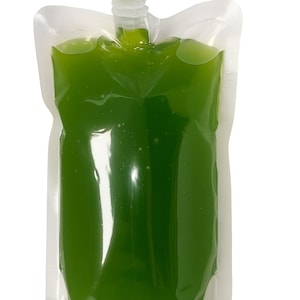 May include: A clear plastic pouch filled with green liquid, featuring a white spout and cap. The text "16oz" is printed in red at the top left. The pouch is sealed and stands upright against a white background.