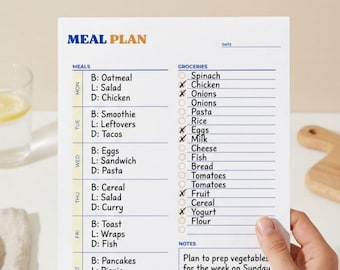 Op de afbeelding: Een witte gezinsmaaltijdplanner met een blauwe koptekst "MEAL PLAN". De planner geeft maaltijden voor elke dag van de week, met selectievakjes voor boodschappen. De tekst "Family Meal Planner" en "Easy Weekly Meals" staan bovenaan.