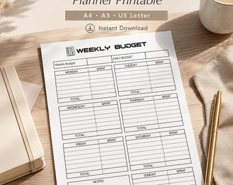 Op de afbeelding: Een afdrukbare wekelijkse budgetplanner met de tekst "Weekly Budget Planner Printable" en "Instant Download". De planner bevat secties voor dagelijkse en wekelijkse uitgaven, met ruimte voor notities. Een kopje koffie en een gouden pen zijn ook zichtbaar.