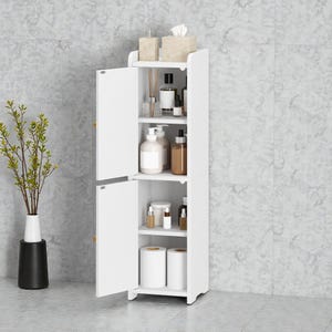 May include: A white, freestanding bathroom cabinet with two doors, open to reveal shelves stocked with toiletries, bottles, and two rolls of toilet paper. The cabinet is next to a vase with a plant.
