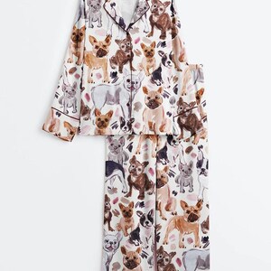 K&ouml;nnte beinhalten: Eine wei&szlig;e Keramik-Tasse mit schwarzem Henkel und dem Text "But First, Coffee" in fetter, schwarzer Schrift. Die Tasse steht vor einem verschwommenen Hintergrund, der eine gem&uuml;tliche Umgebung andeutet.