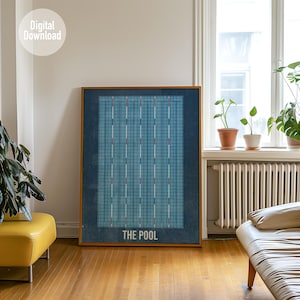 Puede incluir: Un estampado enmarcado de una piscina, con un diseño de cuadrícula azul y marcadores de carril blancos y rojos. El texto "THE POOL" está en la parte inferior. El estampado se exhibe en una habitación con un puf amarillo y una ventana.