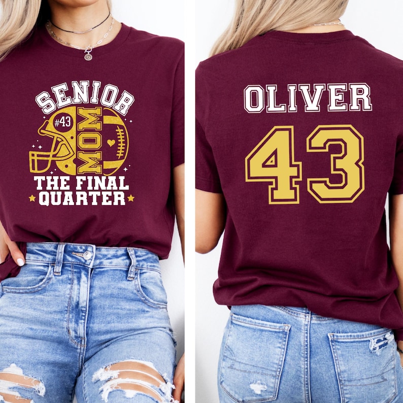 May include: A maroon t-shirt featuring a front graphic with a football helmet, the text SENIOR MOM THE FINAL QUARTER, and the number 43. The back of the shirt displays the name OLIVER in white letters above the large gold number 43 with a white outline.