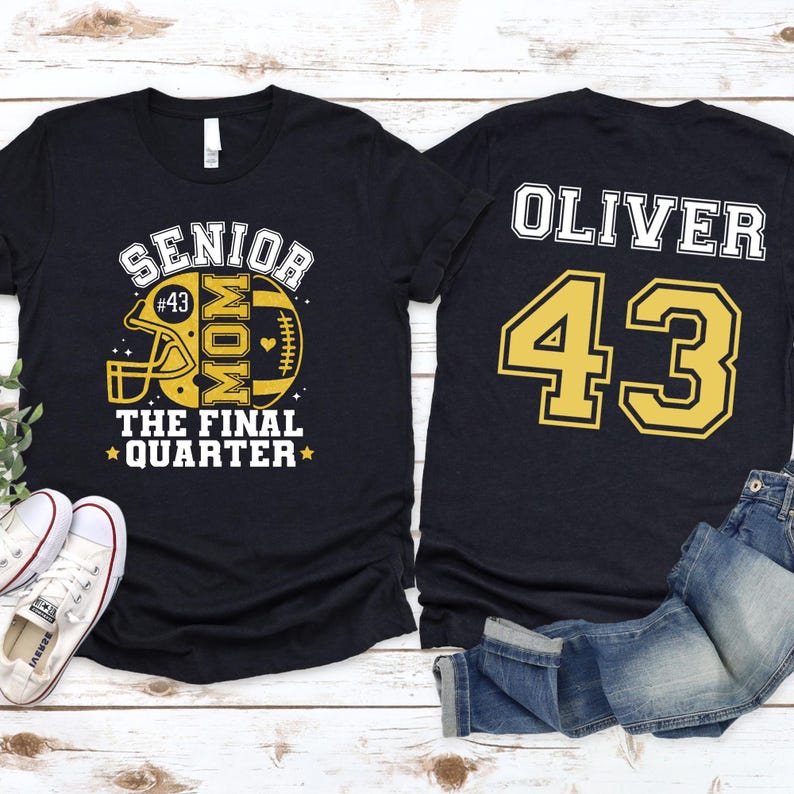May include: A black short-sleeved t-shirt featuring a yellow and white graphic on the front with a football helmet, the text SENIOR MOM THE FINAL QUARTER, and the number 43. The back displays the name OLIVER and the large yellow number 43.