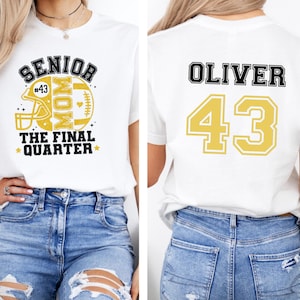 May include: A white t-shirt featuring a front graphic with a yellow football helmet, the text SENIOR MOM, and THE FINAL QUARTER. The back of the shirt displays the name OLIVER in black block letters above the large yellow number 43 in a varsity font.
