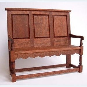 May include: A wooden bench with a high back and carved details. The bench has three panels on the back and a curved bottom edge. The bench has turned legs and arms.