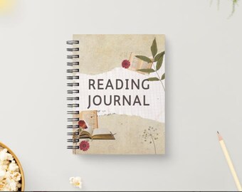 May include: A spiral-bound reading journal with a beige cover featuring the words "READING JOURNAL" in black. The cover has a torn paper design with floral and book illustrations. The journal is on a white surface.