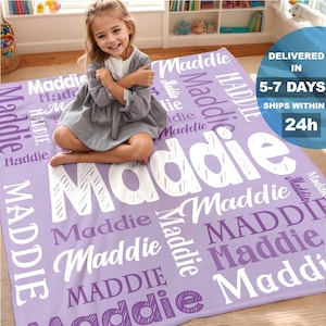May include: A lavender blanket with the name "Maddie" printed in white in various fonts and sizes. The blanket is rectangular and appears to be soft. The text "Delivered in 5-7 days, ships within 24h" is also visible.