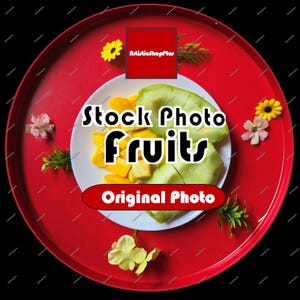 Könnte beinhalten: Ein farbenfrohes Bild von geschnittenen Mangos und grünen Früchten auf einem weißen Teller, präsentiert auf einem roten Tablett. Der Text "Stock Photo Fruits" und "Original Photo" sind sichtbar. Dekorative Blumen und Grün umgeben den Teller.