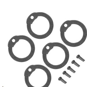 Puede incluir: Cinco anillos de retención de color gris oscuro con un diseño circular y un pequeño agujero en un lado. También se incluyen cinco pequeños remaches de color gris oscuro. Los artículos están dispuestos sobre un fondo blanco.