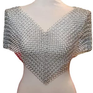 以下が含まれることがあります： 深いVネックデザインのシルバーチェーンメイルカウル。 金属メッシュはマネキンにドレープされており、衣服の形状と質感を際立たせています。 カウルは首と肩を保護するように設計されています。
