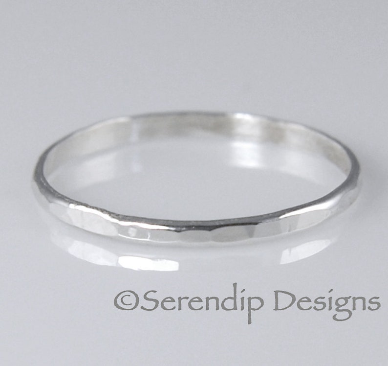 May include: A simple silver hammered band ring.