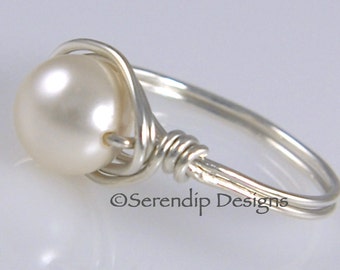 May include: A silver wire wrapped ring with a white pearl. The ring is made by Serendip Designs.