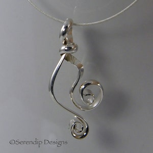 May include: A silver pendant with a swirling, abstract design. The pendant features a looped top, a flowing central element, and a spiral at the bottom. The design is minimalist and modern, suspended on a thin silver chain.