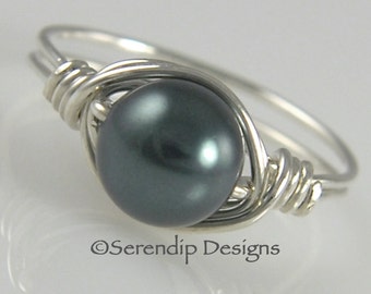 May include: A silver wire wrapped ring with a dark gray pearl. The ring is simple and elegant.