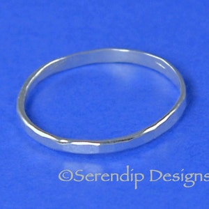 May include: A silver hammered ring on a blue background.  &copy;Serendip Designs