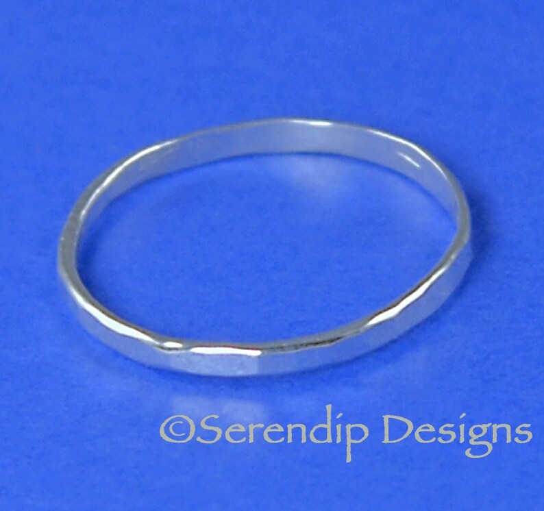 May include: A silver hammered ring on a blue background.  &copy;Serendip Designs
