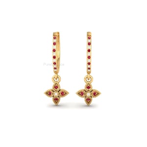 Op de afbeelding: Een paar goudkleurige oorringen met een bloemenhanger. De ringen zijn afgezet met kleine rode en witte steentjes. De bloemenhanger heeft rode steentjes en een centrale witte steen.